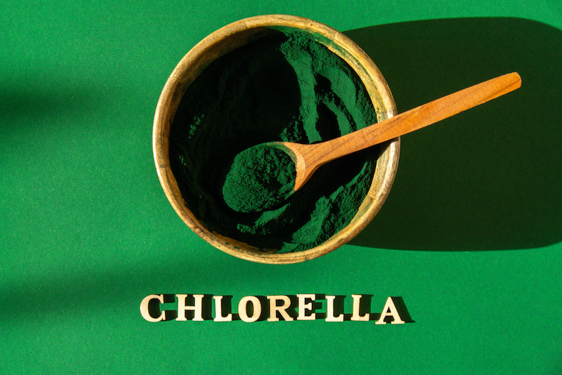 Schüssel mit Holzlöffel und zermahlenem Chlorella