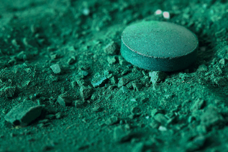 Close-up von Spirulina-Pressling auf Algenpulver